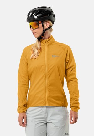 Geel lichtgewicht fietsjack met hoge kraag en volledige ritssluiting, gecombineerd met een zwarte helm en reflecterende getinte zonnebril.
