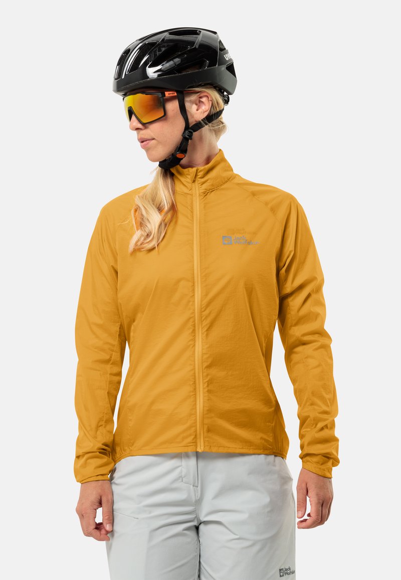 Giacca da ciclismo leggera gialla con colletto alto e zip integrale, abbinata a un casco nero e occhiali da sole riflettenti e tentati.