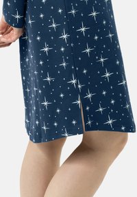 Abito blu marina con motivo a stelle bianche, caratterizzato da una fessura laterale e maniche lunghe, realizzato in tessuto morbido con una texture liscia.