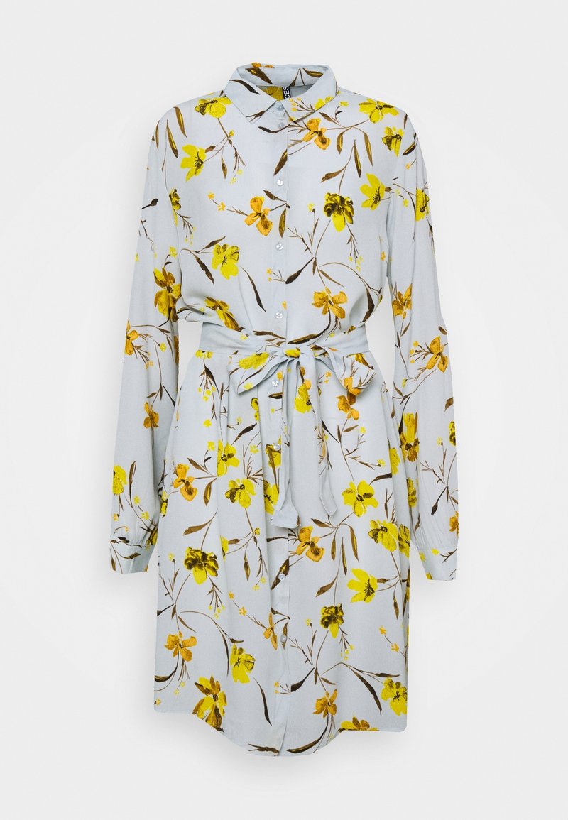 Robe fleurie en tissu bleu clair avec des fleurs jaunes et des tiges brunes. Caractérisée par un col, des manches longues, une fermeture à boutons et une ceinture nouée à la taille.