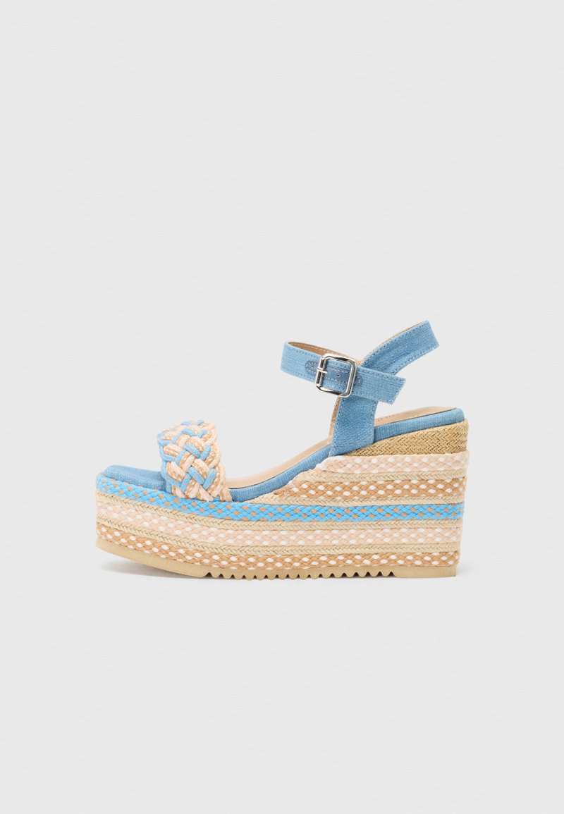 Wedge sandals with a blue fabric upper, braided detail, and ankle strap. Features a cork-like textured base with woven jute detailing.