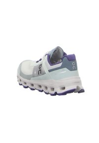 Chaussure de sport en mesh bleu clair et blanc avec des accents violets, présentant un bout arrondi, une semelle épaisse avec des découpes et un détail logo.