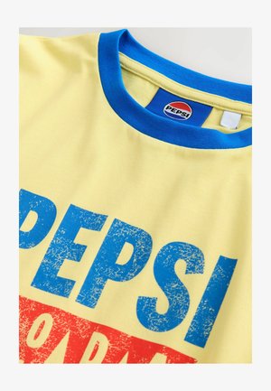 Gul t-shirt med blå rund halsringning, med stor blå och röd sliten text som säger "PEPSI". Märke synligt inuti kragen.