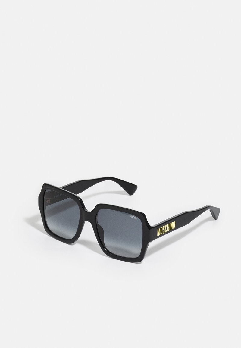 Mustad mustad päikeseprillid hallide gradient läätsedega; sisaldab peeneid detaile ja "MOSCHINO" brändimist kollasena varre peal.