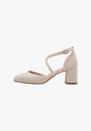 Beige suede low-heeled pump with rounded toe and ankle strap featuring a silver buckle.