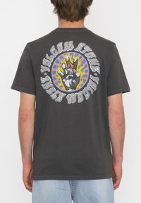 Camiseta de algod�ón gris con un gráfico colorido de una mano rodeada de texto en negrita y llamas psicodélicas en la parte posterior. Manga corta.