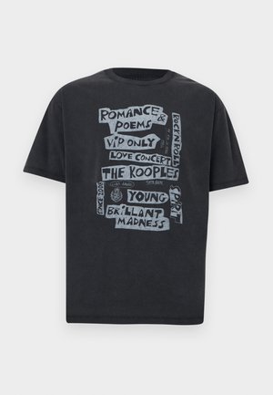 Crna majica kratkih rukava sa sivim tekstom u stilu rukopisa koji sadrži fraze poput "Romance & Poems", "VIP Only" i "The Kooples".