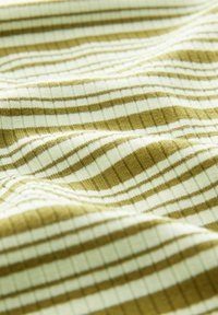 Tissu doux avec une texture côtelée horizontale en rayures alternées vert olive et blanc, présenté en gros plan avec des plis délicats.
