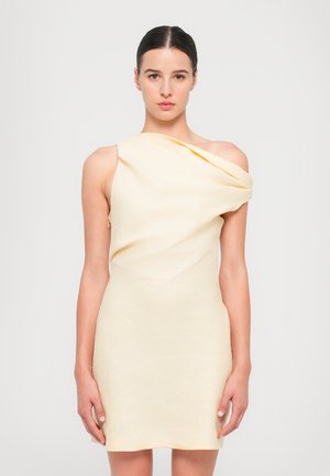Asymmetrische gele jurk van zachte, gedrapeerde stof, met een ontwerp met één schouder en een aansluitende silhouet, met minimale details.