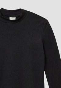 Zwarte longsleeve shirt met een hoge, ronde halslijn en een klein wit merklabel aan de binnenkant van de kraag.