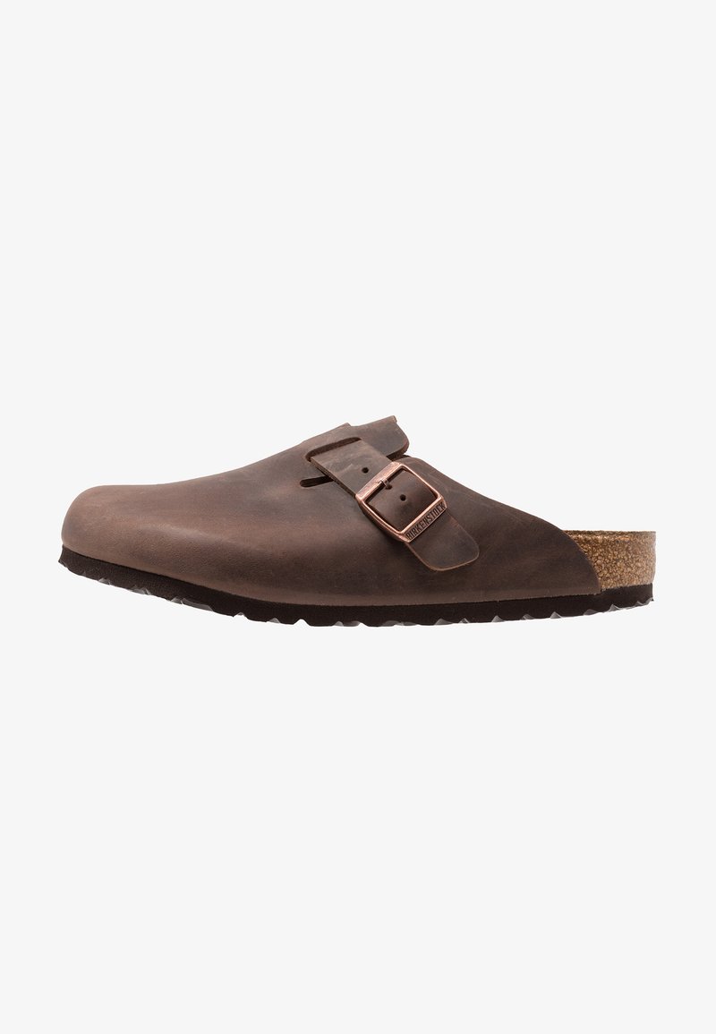 Clog din piele maro cu o cutie de deget largă, curea ajustabilă cu cataramă metalică și talpă din plută-latex. Talpă din cauciuc cu textură pentru aderență.