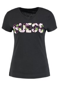 Mustapaita, jossa on V-pääntie ja lyhyet hihat, koristeltu kukkakuosisella "GUESS"-logolla vaaleanpunaisina, vihreinä ja purppuroina väreinä.