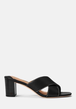 Sort open-toe mule sandal med mellemhøj blokhæl og brede krydsede læderremme med hvid syning.