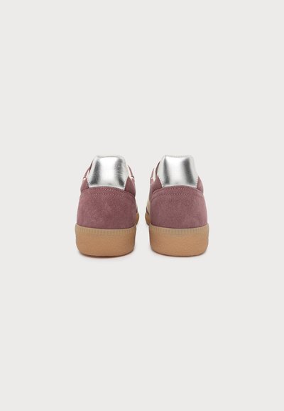 Paire de baskets en suède mauve avec semelles en gomme et empiècements argentés métallisés au talon, présentées de dos sur un fond clair uni.