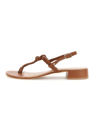 Sandalia de cuero marrón con tacón bajo, diseño de tira en T anudada y hebilla ajustable en el tobillo, sobre fondo blanco.