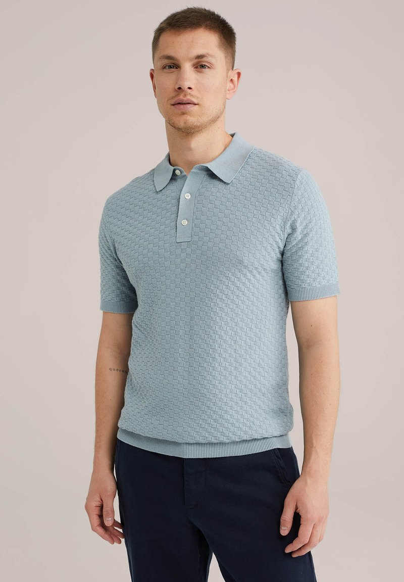 Svetlo modra polo majica s kratkimi rokavi, izdelana iz teksturirane pletenine, z ovratnikom in tremi belimi gumbi. Elastični manšeti in rob.