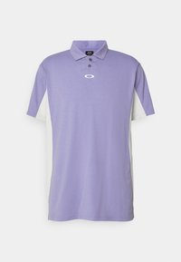 Chemise polo violette avec un col, boutons noirs et logo sur la poitrine. Présente des panneaux en maille blanche sur les côtés pour le contraste et la ventilation.