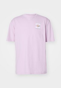 Jasnofioletowy t-shirt z krótkim rękawem z małym nadrukiem na przodzie, na którym widnieje napis "ZJEDNOCZONA MŁODZIEŻ JEST PRZYSZŁOŚCIĄ" w białych i turkusowych literach.