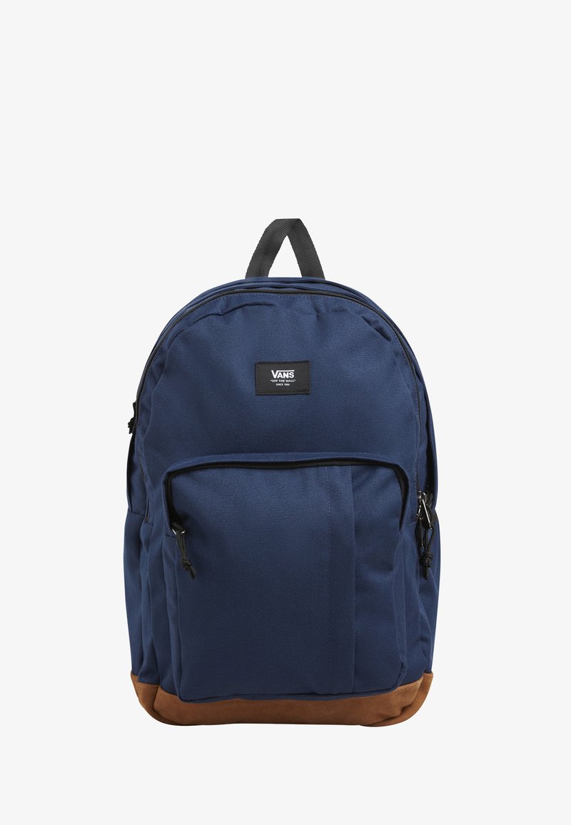 Sac à dos bleu marine avec fond marron, en tissu, équipé d'une poignée supérieure, d'une poche zippée avant et d'un patch logo Vans sur le devant.