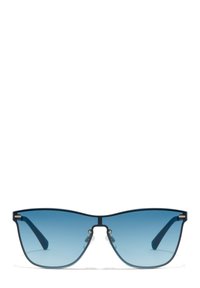 Ochelari de soare tip "cat-eye" cu lentile gradient albastre, cadru din metal negru, brațe subțiri și suporturi pentru nas pentru confort. Include accente aurii pe cadru.