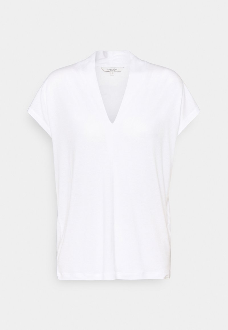 White short-sleeve top made of lightweight fabric with a V-neck design. Features a relaxed fit and side slits for ease of movement.