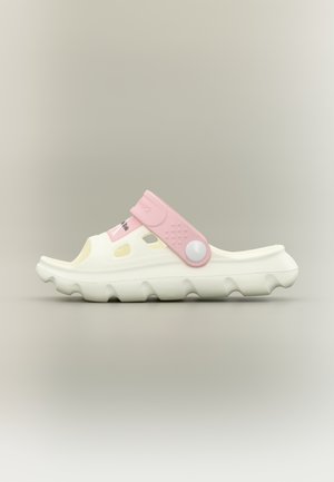 Sandalo bianco slip-on con suola ondulata, fori di ventilazione e cinturino regolabile rosa con bottone rotondo bianco.