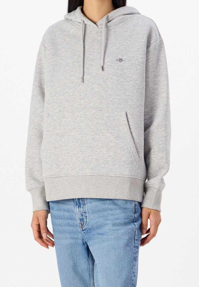 Hoodie gris en mélange de coton, avec une poche avant, une capuche à cordons et un petit logo brodé sur la poitrine.