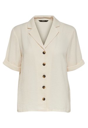 Chemise beige à manches courtes avec col cranté et cinq boutons marron sur le devant, manches retroussées.