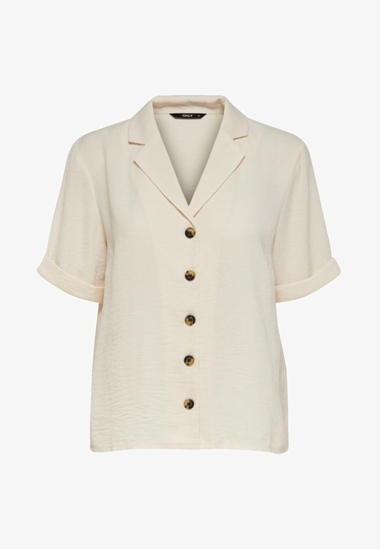 Chemise beige à manches courtes avec col cranté et cinq boutons marron sur le devant, manches retroussées.