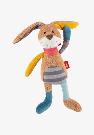 Soft brown plush bunny with a striped gray belly, long ears, one raised arm, and mismatched blue and yellow limbs, wearing a red neck scarf.