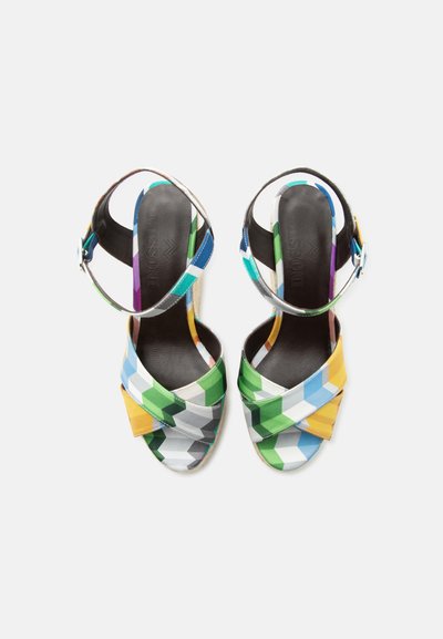 Paire de sandales à talons ouverts avec un motif géométrique multicolore et des brides à la cheville avec boucles, vues de dessus sur fond blanc.