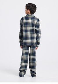 Marineblauw en groen geruit flanellen pyjama-ensemble met een lange mouwen blouse met knopen en loszittende broek, voorzien van een kraag en een zachte textuur.