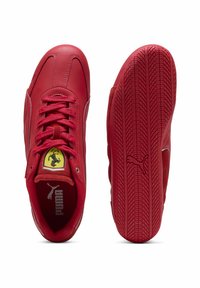 Røde lædersneakers med tekstureret finish, der har snørebånd og et gult Ferrari-logo på tunge. Sålen har et mønstret slidbane.