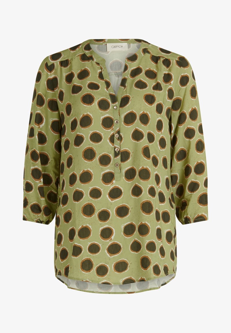 Zelená blůza s V-výstřihem, dlouhými rukávy, zapínáním na knoflíky a vzorem velkých hnědých kruhů obrysovaných bílou barvou. Hladká textura látky.