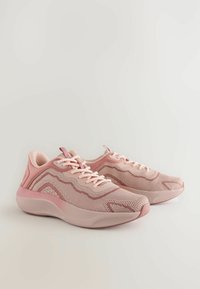 Baskets de sport rose clair avec une tige en mesh, des accents texturés et une semelle extérieure en caoutchouc lisse. Elles présentent un design à lacets et un col rembourré.