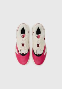 Sneakers with a white and pink textured upper, black accents, and perforated detailing on the pink sections. Lace-up design and cushioned insoles.