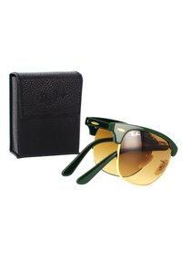 Occhiali da sole con montatura in plastica verde e lenti color oro, accompagnati da un astuccio nero testurizzato con logo impresso.