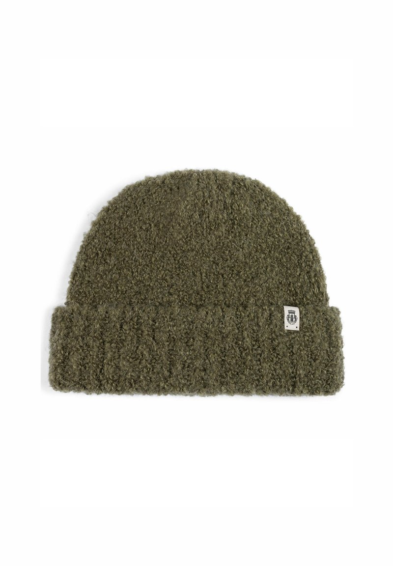 Olive green knitted beanie hat with folded ribbed cuff and small white fabric tag on cuff's edge.
