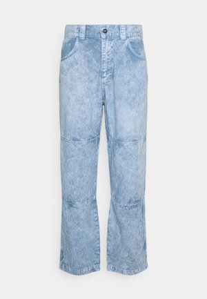 Pantalones vaqueros de mezclilla lavado ácido en azul claro con cierre frontal de botón y cremallera, trabillas para cinturón, dos bolsillos frontales y paneles cosidos en las rodillas.
