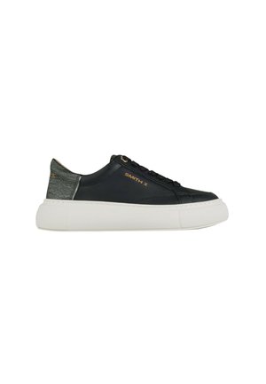 Czarny niskoprofilowy sneaker z białą grubą podeszwą, wiązaniem z przodu, teksturowanym obcasem i złotym logo "SMITH X" po boku.