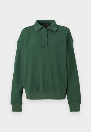 Pulover verde din material waffle, cu guler, fermoar pe un sfert în față, mâneci lungi și manșete și tivuri striate. Textură moale.