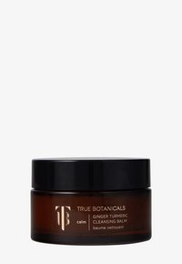 Baume nettoyant au gingembre et au curcuma dans un pot rond en verre ambre avec un couvercle noir. L'étiquette présente un texte doré avec le nom du produit et le logo de la marque.
