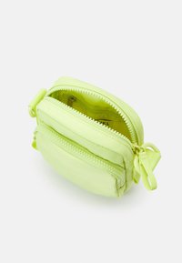 Piccola borsa in nylon verde lime con due scomparti con cerniera e un anello per facilitare il trasporto. Texture liscia con dettagli della cerniera coordinati.