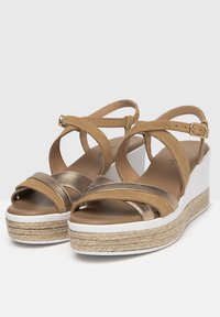 Sandali wedge in bronzo e beige con cinturini incrociati, materiale scamosciato e suola avvolta in juta con una base in gomma bianca.
