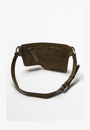 Mørkebrun ruskind bæltetaske med en lynlåslomme foran og justerbar rem med spænde og ringe i sølvfarvet metal.