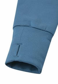 Manica in cotone blu con estremità a coste, dettagli cuciti e un leggero apribile, progettata per comfort e flessibilità.