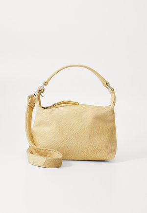 Sac à main en fausse fourrure jaune avec une texture lisse, une forme arrondie, une seule poignée et une longue sangle réglable. Dispose d'une fermeture éclair sur le dessus.