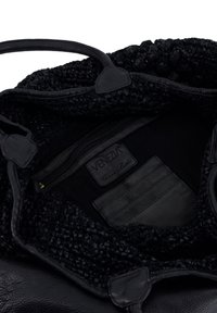 Černá kožená kabelka s pletenou texturou na horní části. Má kapsu na zip a vnitřní přihrádky na karty. Vnitřní podšívka je z tmavé látky.