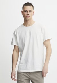 White cotton t-shirt with a crew neckline and short sleeves, featuring a small logo on the chest. Smooth, relaxed fit.