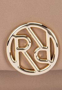 Beige material with a smooth texture, featuring a prominent gold circular logo design with interlocking letters R and D.